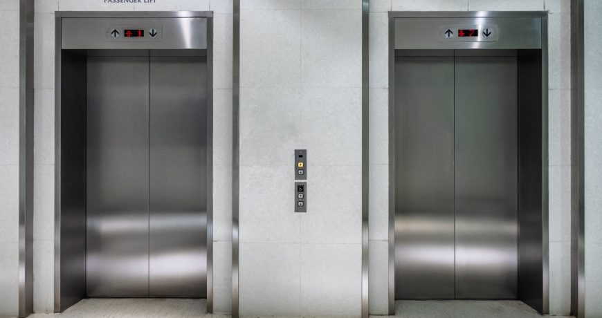 Metallic elevator two gate closed of passenger lift at lobby